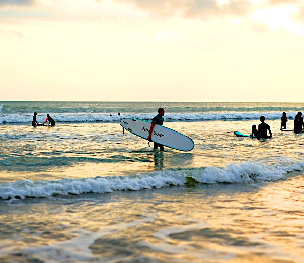 Surfer walking Indonesian Beach